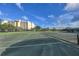 Well-maintained tennis court with net, under a bright blue sky with scattered clouds at 11351 Shipwatch Ln # 1844, Largo, FL 33774