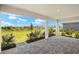 Open-air patio with beautiful views, stone pavers, and white structural supports at 11470 Myakka Blue Dr, Venice, FL 34293