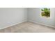 Bedroom with a window providing natural light and neutral colored carpet at 11520 Myakka Blue Dr, Venice, FL 34293