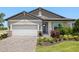 Charming single-Gathering home boasts a two-car garage and beautifully landscaped front yard at 11520 Myakka Blue Dr, Venice, FL 34293