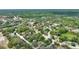 The aerial view displays a calm neighborhood surrounded by trees, residential streets, and a pond at 11940 Terra Ceia Ave, New Port Richey, FL 34654