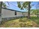 Fenced backyard with mature trees and side view of the home at 11940 Terra Ceia Ave, New Port Richey, FL 34654