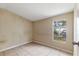 Bedroom features neutral walls and tile flooring, illuminated by a window at 11940 Terra Ceia Ave, New Port Richey, FL 34654