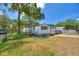 Quaint single-story home with mature trees, fenced yard, and a convenient carport at 11940 Terra Ceia Ave, New Port Richey, FL 34654