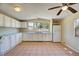 Bright kitchen featuring white cabinets, tile floors, and a large window over the sink at 11940 Terra Ceia Ave, New Port Richey, FL 34654