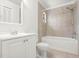 Well-lit bathroom with a white sink, toilet, and tiled shower-tub combination at 12002 Peony Ct, Tampa, FL 33635