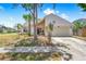 Charming single-story home with a two-car garage, lush landscaping, and a well-manicured lawn on a sunny day at 12002 Peony Ct, Tampa, FL 33635