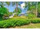 View of the front exterior with lush landscaping, featuring a driveway and walkway to the front door at 127 Lake Judy Lee Dr, Largo, FL 33771