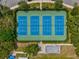 Aerial view of tennis courts in a well-maintained community with trees at 128 Brandy Wine Dr, Largo, FL 33771