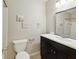 A bathroom with a dark vanity, a mirror, artwork, and a toilet that includes a towel holder at 128 Brandy Wine Dr, Largo, FL 33771