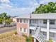 Condo exterior featuring a brick facade, white railings, and staircase leading to the upper level units at 128 Brandy Wine Dr, Largo, FL 33771