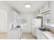 White kitchen featuring tile countertops, a window with a view, and modern appliances at 128 Brandy Wine Dr, Largo, FL 33771
