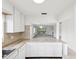 Bright kitchen leading into a spacious living area with neutral colored carpet and a modern pendant light at 128 Brandy Wine Dr, Largo, FL 33771
