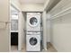 A laundry closet featuring a stacked washer and dryer, with additional storage shelves for convenience at 128 Brandy Wine Dr, Largo, FL 33771