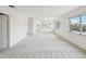 The living room features neutral colors, plush carpeting, and an open concept layout with multiple windows for natural light at 128 Brandy Wine Dr, Largo, FL 33771