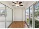 The sunroom boasts hardwood floors, a ceiling fan, glass walls, and natural light to provide a relaxing space at 128 Brandy Wine Dr, Largo, FL 33771