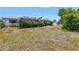 View of a large backyard with overgrown vegetation, shrubs covering the rear exterior of the house at 1301 62Nd S Ter, St Petersburg, FL 33705
