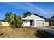 Charming single-story home featuring a well-maintained front yard and attached garage in a residential neighborhood at 13018 Clay Ave, Largo, FL 33773