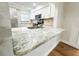 Kitchen featuring granite breakfast bar, stainless steel sink and appliances, and white cabinets at 13018 Clay Ave, Largo, FL 33773
