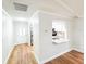 Open living space with new floors that flows into a kitchen and into the home's entrance at 13018 Clay Ave, Largo, FL 33773