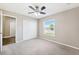 Bright bedroom with soft carpet, a ceiling fan, closet, and a large window at 13040 Hanley Dr, Spring Hill, FL 34609