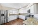Modern kitchen features stainless steel appliances, granite counters, and white cabinets at 13040 Hanley Dr, Spring Hill, FL 34609