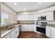 Modern kitchen features stainless steel appliances, granite counters, and white cabinets at 13040 Hanley Dr, Spring Hill, FL 34609