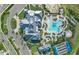 Aerial view of the community center with pool, tennis courts, parking, and a lush landscape at 14727 Eagle Branch Dr, Nokomis, FL 34275