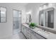 Bright bathroom featuring a double sink vanity with modern fixtures and an enclosed glass shower with marble tiling at 14727 Eagle Branch Dr, Nokomis, FL 34275