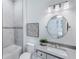 Bathroom featuring a tub/shower combo, modern single sink vanity and a round mirror with modern light fixture at 14727 Eagle Branch Dr, Nokomis, FL 34275