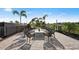 An outdoor fire pit and seating surrounded by manicured landscaping and palm trees at 14727 Eagle Branch Dr, Nokomis, FL 34275