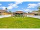 Backyard view of the home shows a green lawn and a white fence at 1535 Crossvine Ct, Trinity, FL 34655
