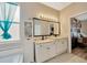 Bathroom features a double sink vanity with a cabinet, large mirror, and stylish fixtures and a view to the bedroom at 1535 Crossvine Ct, Trinity, FL 34655