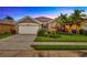 Charming single-story home featuring a well-manicured lawn, mature palm trees, and an attached two-car garage at 1535 Crossvine Ct, Trinity, FL 34655