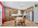 Well-lit kitchen area featuring stainless steel appliances, brown cabinetry, white countertops, and wood flooring at 1535 Crossvine Ct, Trinity, FL 34655