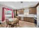 Well-lit kitchen area featuring stainless steel appliances, brown cabinetry, white countertops, and wood flooring at 1535 Crossvine Ct, Trinity, FL 34655