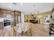 Open floor plan connecting kitchen and living room with a ceiling fan and light wood flooring at 1535 Crossvine Ct, Trinity, FL 34655