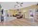 Spacious living room with light wood flooring, a large brown leather sofa, and a ceiling fan at 1535 Crossvine Ct, Trinity, FL 34655