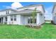 Backyard featuring a covered patio with sliding glass door, green lawn, and landscaping at 15853 Elina Sky Dr, Punta Gorda, FL 33982
