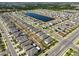 Bird's-eye view of a well-planned neighborhood with neatly arranged houses, roads, and a serene lake at 16704 Sunburst Lake St, Wimauma, FL 33598