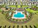 Overhead view of the community pool, clubhouse, and playground with manicured landscaping at 16704 Sunburst Lake St, Wimauma, FL 33598