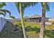 Expansive backyard with healthy grass, mature landscaping, a screened patio, and a secure white fence at 16704 Sunburst Lake St, Wimauma, FL 33598