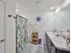 Bright bathroom featuring a double vanity, decorative mirror, a shower with stylish curtain, and tiled floors at 16704 Sunburst Lake St, Wimauma, FL 33598