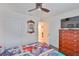 Well-lit bedroom with a mirror, a ceiling fan, and a dresser at 16704 Sunburst Lake St, Wimauma, FL 33598