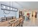 Well-lit dining room flowing into kitchen featuring modern lighting and rustic wood table at 16704 Sunburst Lake St, Wimauma, FL 33598