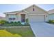 Charming single-story home featuring a well-maintained lawn, landscaped garden beds, and a two-car garage at 16704 Sunburst Lake St, Wimauma, FL 33598