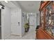 Inviting hallway with tiled flooring, neutral walls, decorative furniture, and classic display cabinet at 16704 Sunburst Lake St, Wimauma, FL 33598