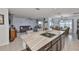 Kitchen featuring a large island with sink, seating and a view into the living and dining areas at 16704 Sunburst Lake St, Wimauma, FL 33598