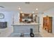 Kitchen island with a sink and granite countertops, complemented by stainless steel appliances and dark wood cabinets at 16704 Sunburst Lake St, Wimauma, FL 33598