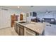 Open kitchen boasts an island with granite countertops and a stainless steel dishwasher at 16704 Sunburst Lake St, Wimauma, FL 33598